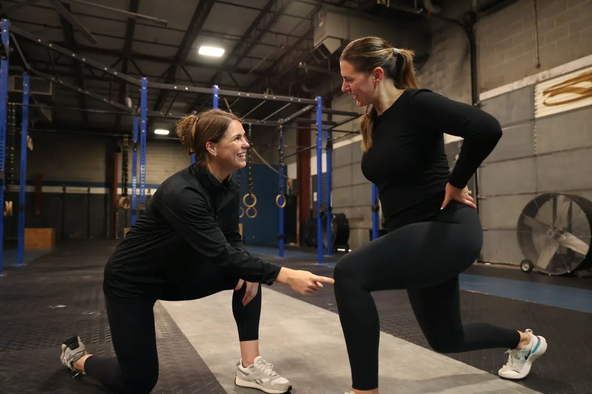 Dr. Kiley points to an athlete's front knee during a lunge