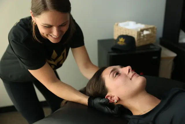 Dr. Kiley smiles while she does a hands-on neck release on a patient